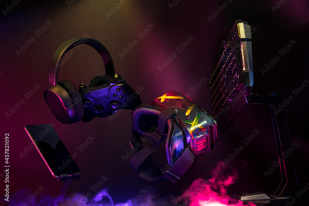 gamer devices for playing game by joystick with computer headphone and mouse on neon glow, gaming and esports challenge, streaming online, tournament concept - obrazy, fototapety, plakaty 