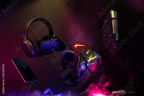 gamer devices for playing game by joystick with computer headphone and mouse on neon glow, gaming and esports challenge, streaming online, tournament concept photo