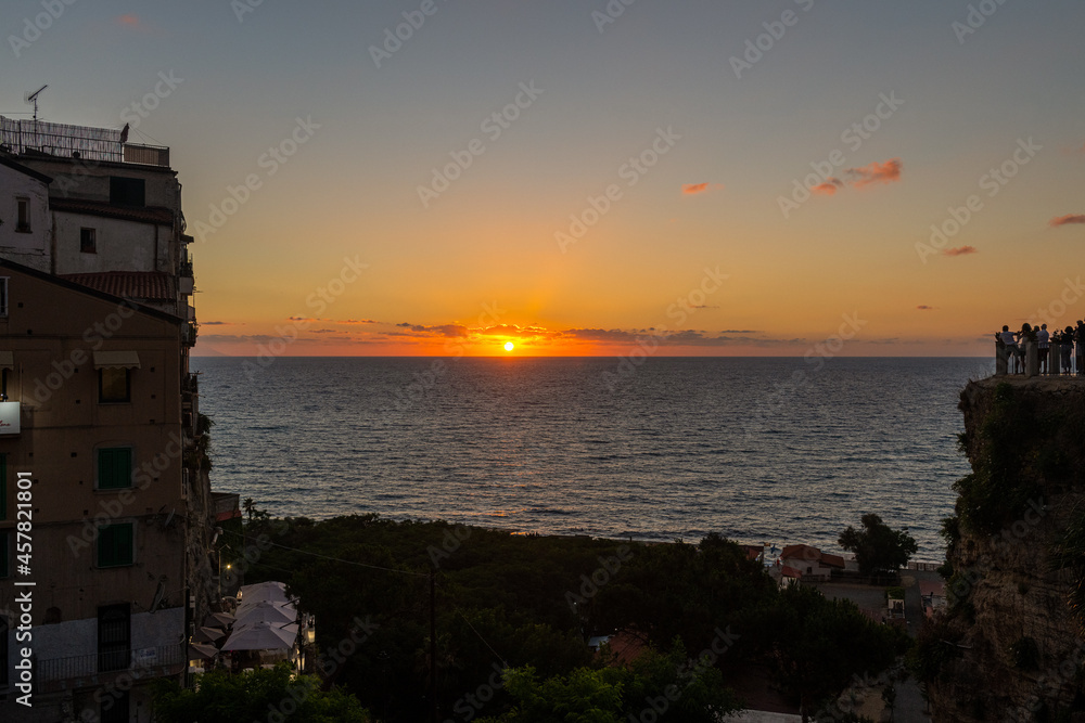 grupa turystów na tarasie widokowym w Tropea podziwia zachód słońca - obrazy, fototapety, plakaty 