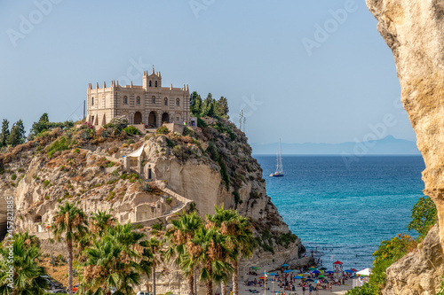 klasztor na wzgórzu na tle pięknego morza i samotnej żaglówki