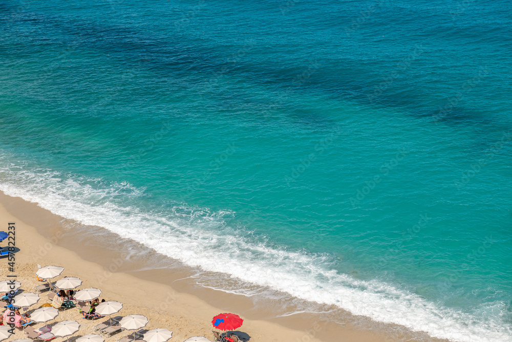 spokojne, łagodne fale rozbijające się o piaszczysty brzeg plaży w Tropea - obrazy, fototapety, plakaty 