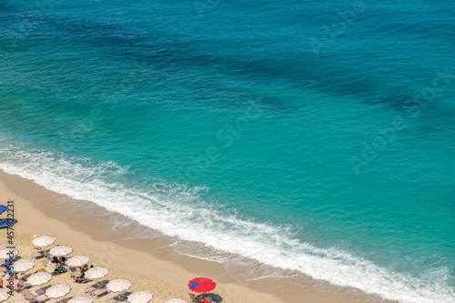 spokojne, łagodne fale rozbijające się o piaszczysty brzeg plaży w Tropea
