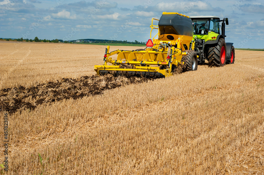 Obraz premium fragment of a disk cultivator, system of tillage in work with the bunker for fertilizers in the field