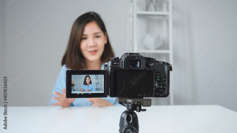 Happy smiling asian woman or beauty blogger with brush and camera recording video and waving hand at home. Beauty videoblog blogging people concept. Dolly shot. Happy smiling asian woman or beauty blogger with brush and camera recording video and waving hand at home. Beauty videoblog blogging people concept. Dolly shot.