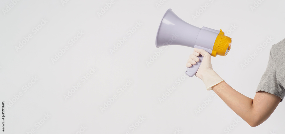 Hand is hold megaphone and wear medical glove on white background.. Hand is hold megaphone and wear medical glove on white background..