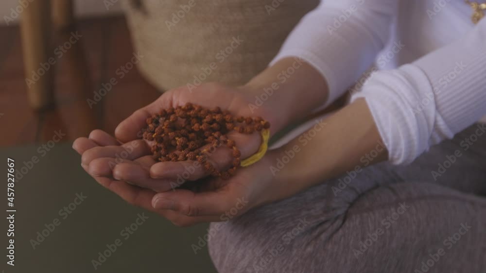 Close Up Of Mala beads in the hand as girl meditates Close Up Of Mala beads in the hand as girl meditates