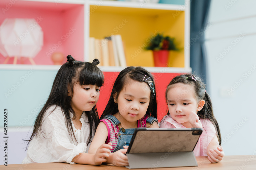 Group of children using tablet in classroom, Multi-ethnic young boys and girls happy using technology for study and play games at elementary school. Kids use technology for education concept. Group of children using tablet in classroom, Multi-ethnic young boys and girls happy using technology for study and play games at elementary school. Kids use technology for education concept.