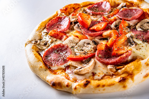 Pizza with Mozzarella cheese, salami, tomato sauce, onion, pepper, mushrooms