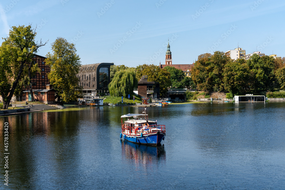 colorful wooden tourist boat cruise on the Brda River in the heart of downtown Bygdoszcz