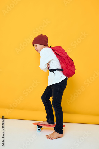 portrait of cute boys with red backpack red skateboard isolated background