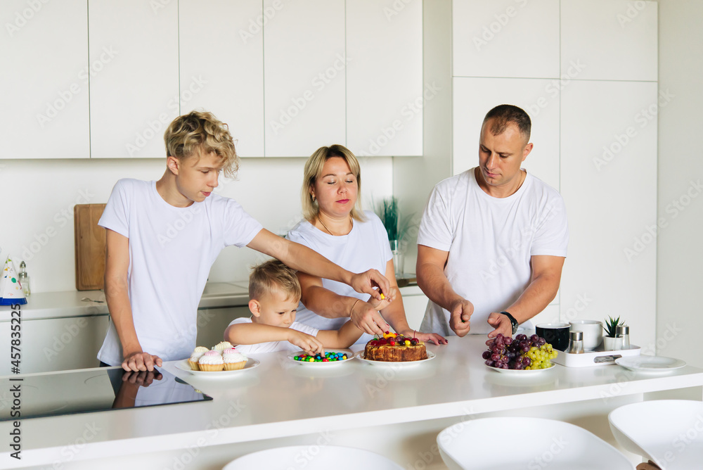 Party. The family smiles and decorates the cake. Party. The family smiles and decorates the cake.