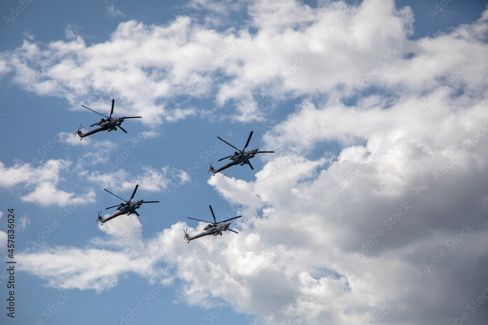 Combat helicopters fly against the background of the cloudy sky. Cloudy sky. Beautiful military aircraft. Combat helicopters fly against the background of the cloudy sky. Cloudy sky. Beautiful military aircraft.