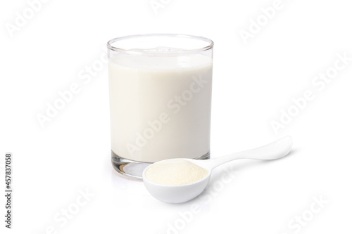 Glass of fresh milk and powdered milk or milk powder in plastic spoon isolated on white background. 