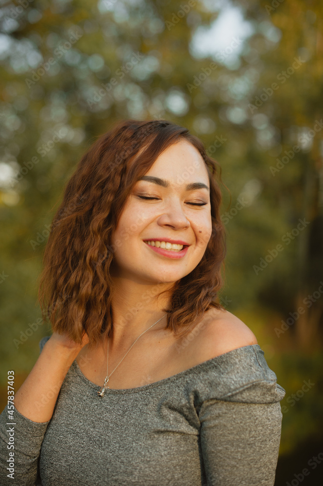 Happy girl with closed eyes straightens curly hair. Happy girl with closed eyes straightens curly hair.