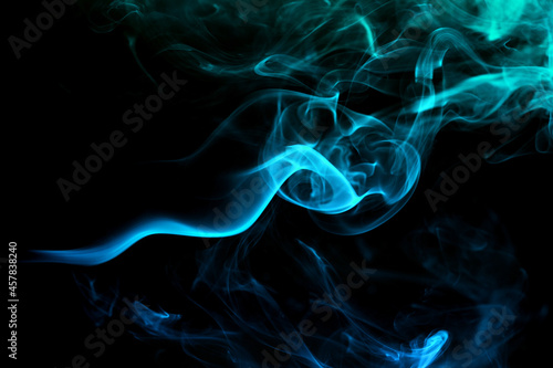 Abstract colored smoke moves on dark background. Wallpaper. Personal vaporizers fragrant steam. Concept of alternative non-nicotine smoking. E-cigarette. Texture. Design elements.