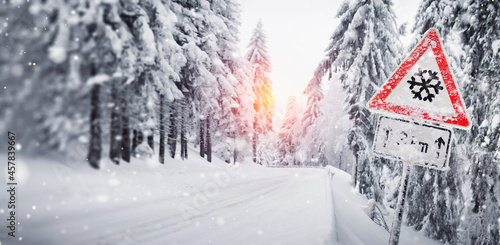 Canvas Print a warning sign of the risk of slipping on the snowy forest road