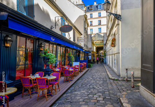 Fototapeta Naklejka Na Ścianę i Meble -  Narrow street with tables of cafe in Paris, France. Cozy cityscape of Paris. Architecture and landmarks of Paris.