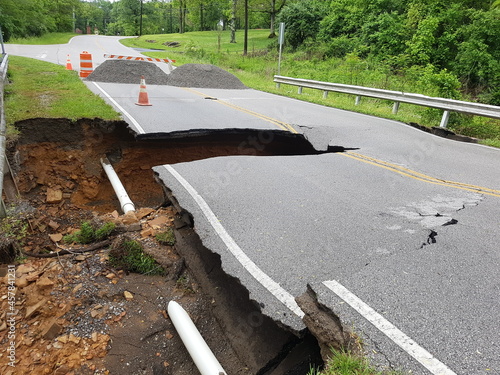 road washed away with exposed pipe photo