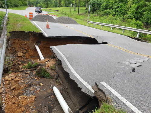 road washed away with exposed pipe photo