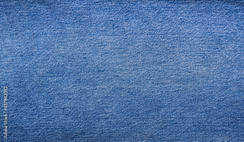 The texture of a beautiful denim of a classic color. Close-up.