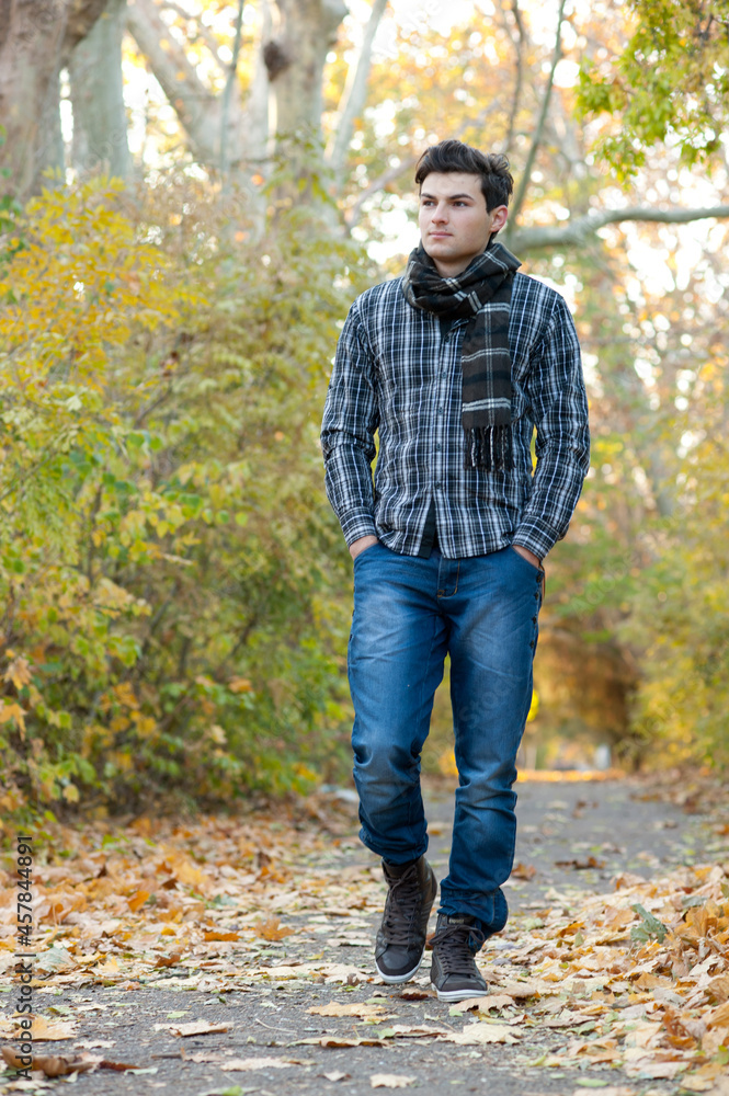Portrait of attractive man dressed in casual wear, have a rest oudoor in autumn park