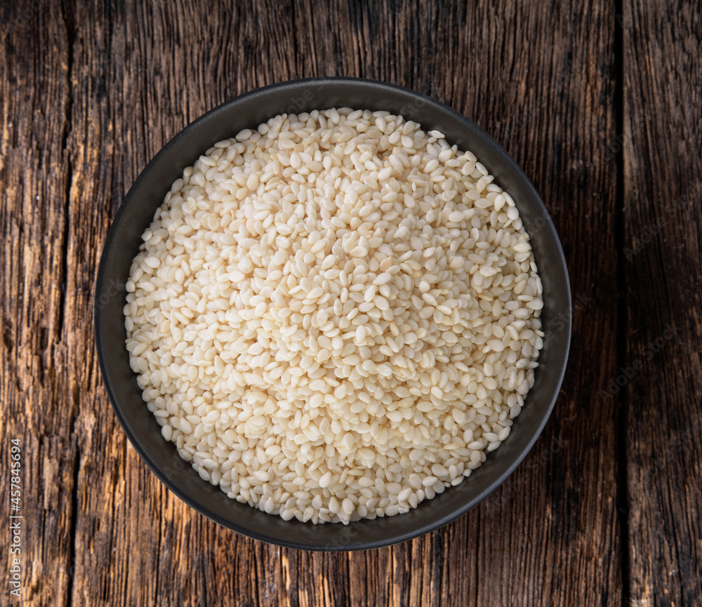 White sesame in a bowl on wood table