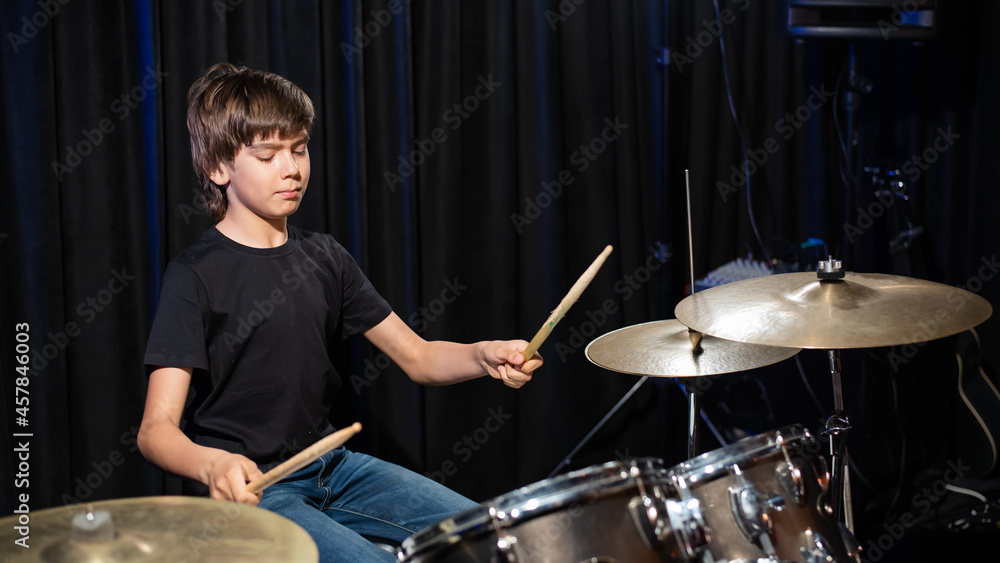 Obraz premium A boy plays drums in a recording studio