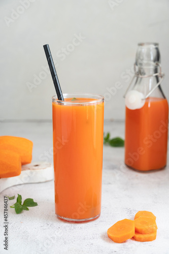 Glass of carrot juice, healthy smoothie drink with paper straw. Nutrition and diet concept