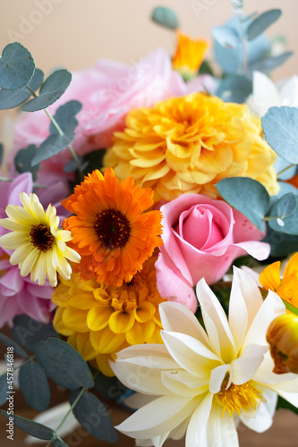 Autumnal abstract flower background. Colorful bouquet in a vase. Dahlia  roses and eucalyptus plant.