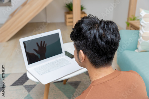 A young man working at home with a laptop