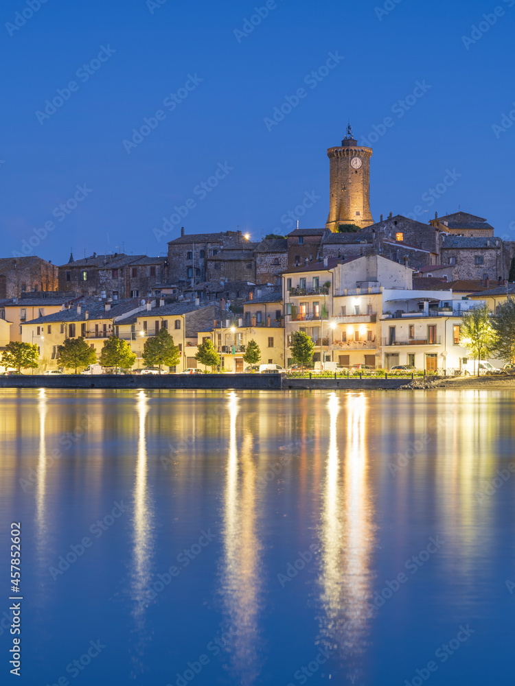 blue hour with golden lights of city Marta on lake Bolsena in Italy