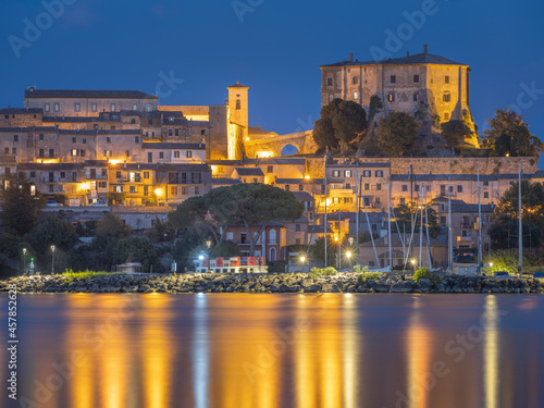 Golden lights of city Capodimonte in twilight time on lake Bolsena in Italy