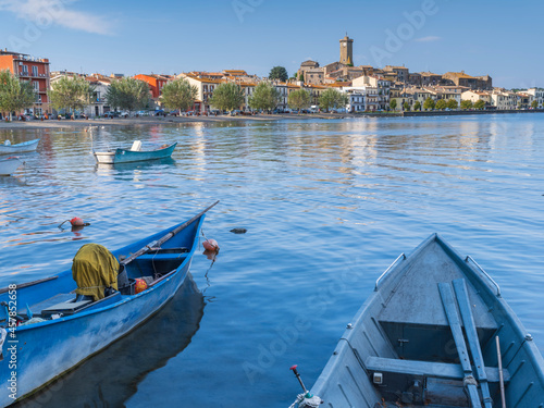 view through boats to city Marta on lake Bolsena in Italy photo
