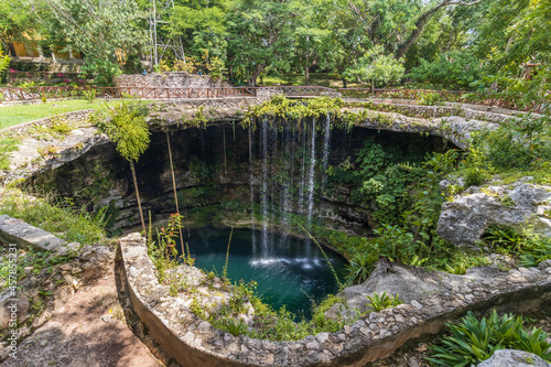 Hermosa vista de una cascada sobre plantas verdes en un cenote, en Yucatán, México