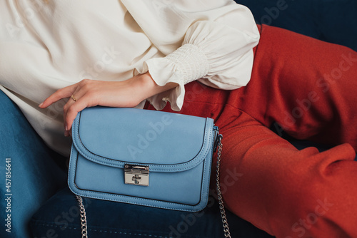 Blue faux leather small rectangle bag in trendy autumn woman outfit. Fashion details. Copy, empty space for text
