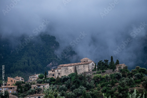 Mist and clouds over a medieval church in Deià, Mallorca, Spain © Stephen