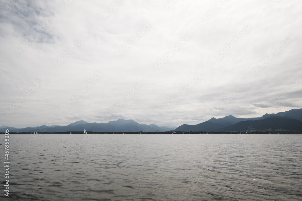 Beautiful landscape with a sailboat on the lake with mountains in the background