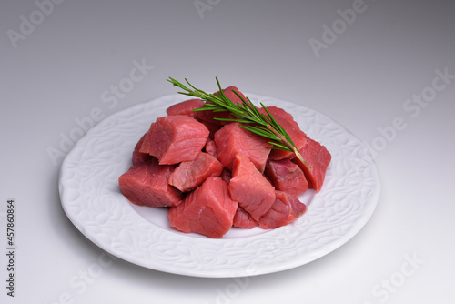 Pile of beef cubes on plate. Fresh raw diced red beef meat. Fresh raw beef cutting in small pieces.  Concept for sale in supermarket for client. 
