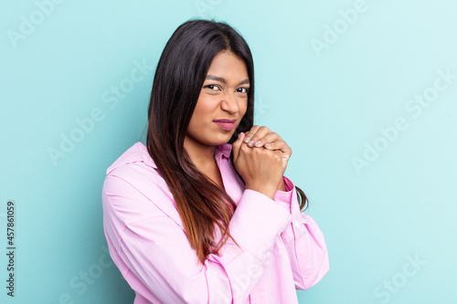 Young Venezuelan woman isolated on blue background scared and afraid.