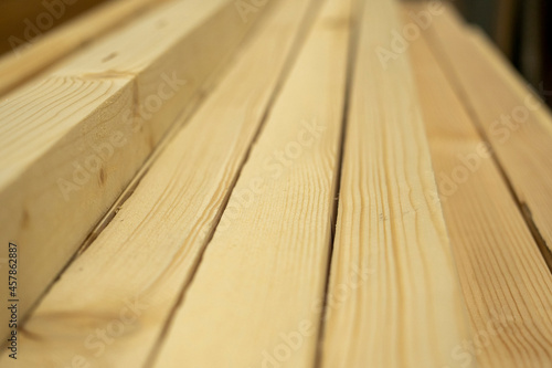 Close-up planed boards lying in a pile. Side view, lumber for construction. Selective focus