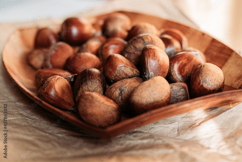 Close up of raw chestnuts in wooden dish. Autumn vibes Close up of raw chestnuts in wooden dish. Autumn vibes