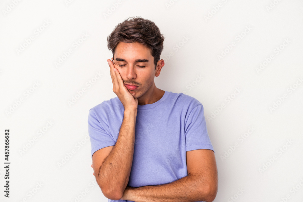 Young mixed race man isolated on white background who is bored, fatigued and need a relax day. Young mixed race man isolated on white background who is bored, fatigued and need a relax day.