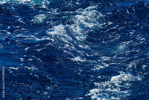 Rapid sea while sailing ship. deep turquoise and blue Mediterranean sea with texture background. Background shot of aqua sea water surface © Ilja
