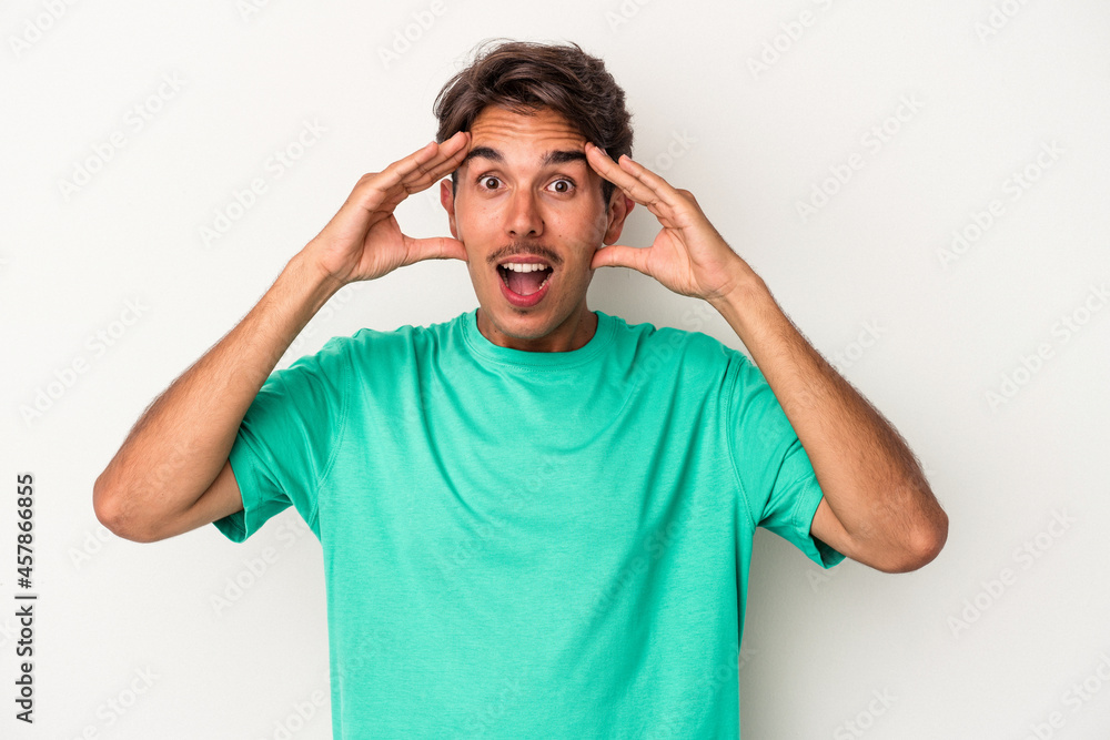 Young mixed race man isolated on white background receiving a pleasant surprise, excited and raising hands. Young mixed race man isolated on white background receiving a pleasant surprise, excited and raising hands.