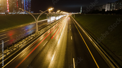 long exposure of the night highway in the city at night during the rain passing cars blurry Right side. High quality photo