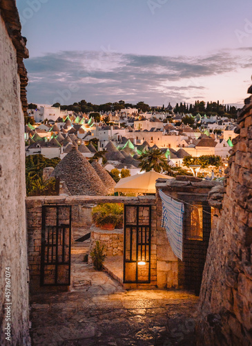 View of the Trulli of Alberobello at sunset with city lights photo