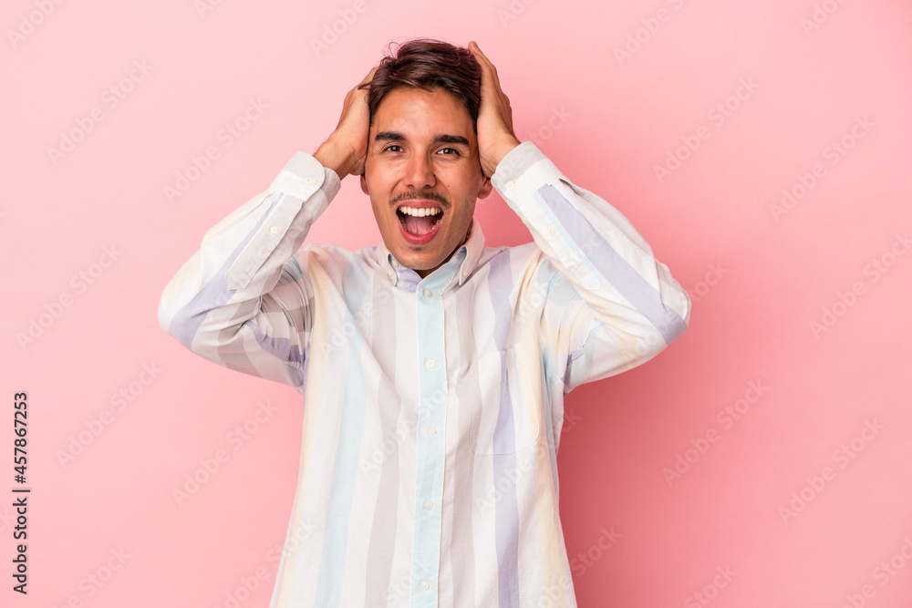 Young mixed race man isolated on white background screaming, very excited, passionate, satisfied with something.