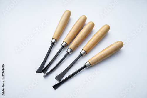 Small chisels for cutting wood on white isolate. Wooden handles.