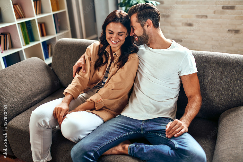 Young couple in love are sitting on the sofa at home. A married couple are relaxing in the living room. Young couple in love are sitting on the sofa at home. A married couple are relaxing in the living room.