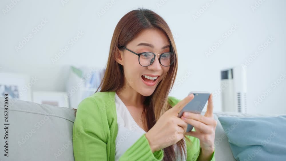 Asian beautiful woman wear eyeglass and chat on mobile phone in house.